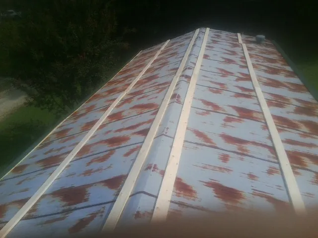 Rusted metal roof panels with new wood purlins before replacement — Storm Damage Roof Repair in Floyd by Roofing Brothers