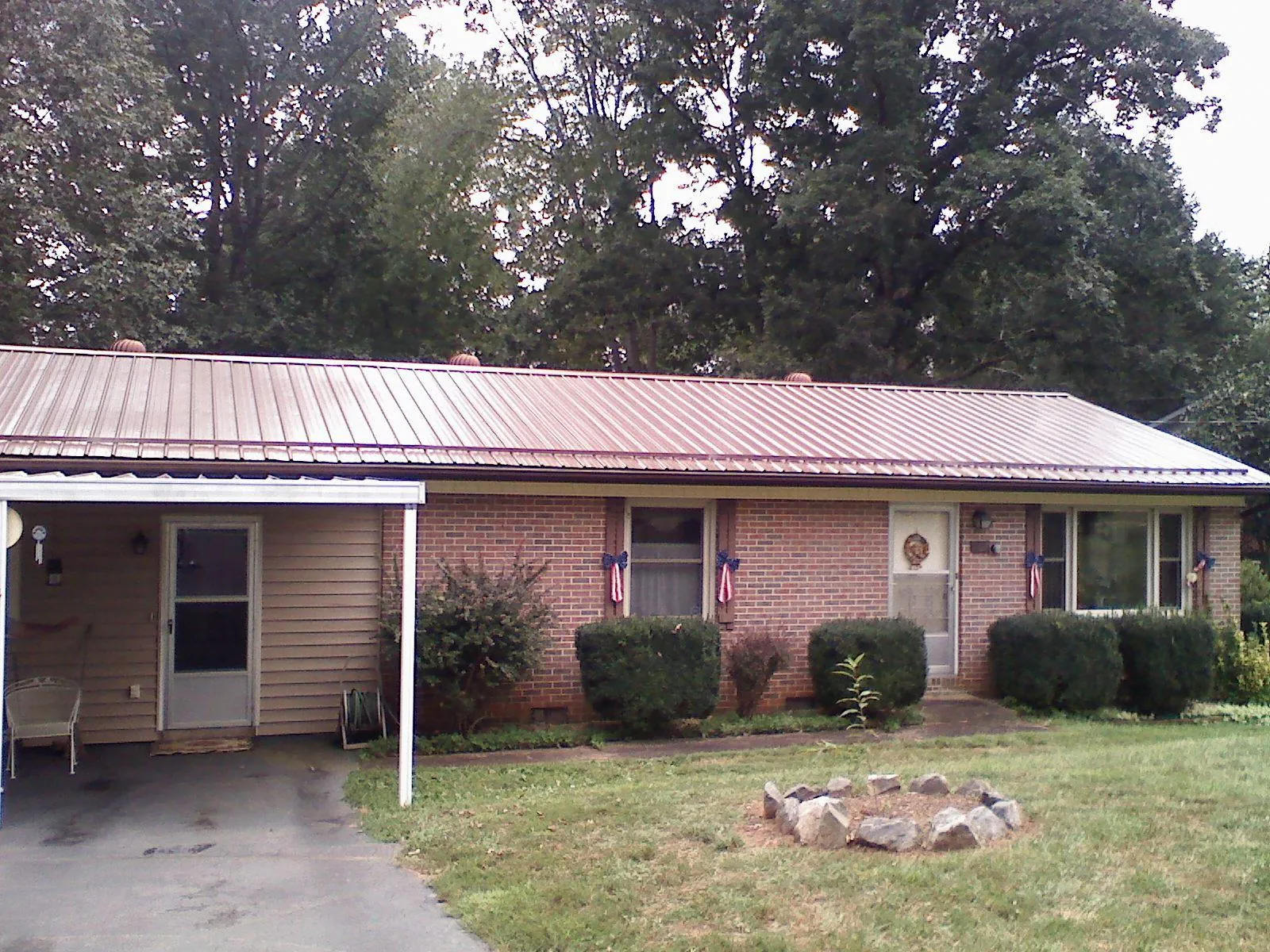 Bronze metal roof and carport on a brick ranch home — Roof Repair work by our crew in Floyd